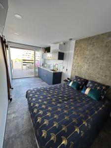 a bedroom with a large bed and a kitchen at LA SUITE DES CHARMES - village naturiste - coursives - port nature 2 in Cap d'Agde