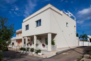 a white building with plants in front of it at Dimora Nesea in Cozze