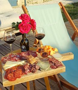 un tavolo con bicchieri da vino e un piatto di cibo di Clos Baroanni - Studio La Volière a Terraube
