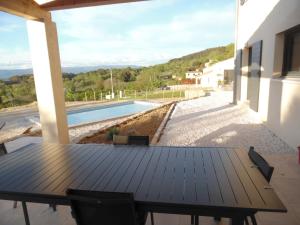 a wooden table on a patio with a swimming pool at Coeur de Bonnieux in Bonnieux