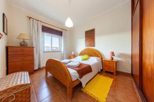 una camera da letto con un letto, una sedia e una finestra di B56 - Baluarte Cul de Sac Flat in Lagos a Lagos