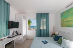a bedroom with a bed and a tv and a window at Dimora Nesea in Cozze