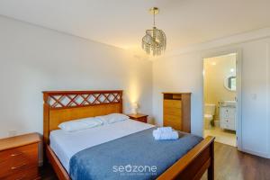 ein Schlafzimmer mit einem großen Bett mit einer blauen Decke in der Unterkunft Apto em Canela de frente ao lago dos patos CBL307 in Canela