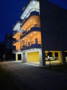 希马拉Amarildo Hotel的晚上侧面有阳台的大楼