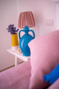 a blue vase sitting on a table with a lamp at Dimora Nesea in Cozze