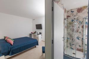 a bedroom with a blue bed and a shower at Dimora Nesea in Cozze