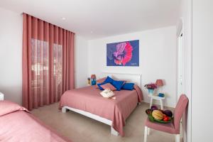 a bedroom with a bed and a table with a bowl of fruit at Dimora Nesea in Cozze +37 photos