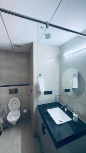 een badkamer met een toilet, een wastafel en een spiegel bij Calestial Grand in Lucknow