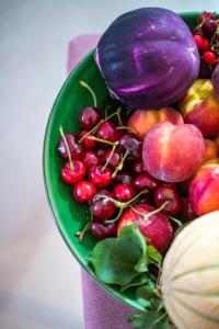 a green bowl of fruits and vegetables on a table at Dimora Nesea in Cozze