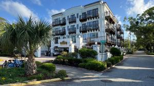 a white building with a palm tree in front of it at Ocean Inn & Suites in Saint Simons Island