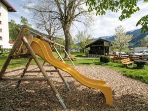 a playground with a yellow slide in a yard at Apartment Manuel by Interhome in Hippach