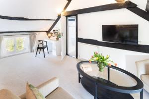 ein Wohnzimmer mit Tisch und Fernseher in der Unterkunft Tranquil 2 bed cottage Sidmouth, rural escape in Salcombe Regis