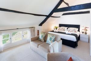 ein Schlafzimmer mit einem Bett und einer Couch in der Unterkunft Tranquil 2 bed cottage Sidmouth, rural escape in Salcombe Regis