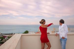 a man and a woman standing on a ledge at Dimora Nesea in Cozze