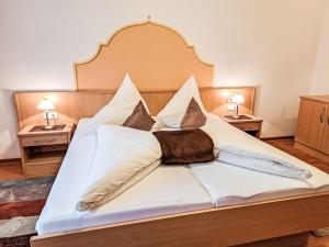 a bedroom with a bed with white sheets and pillows at Apartment Rosa-8 by Interhome in Mayrhofen