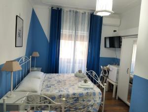 a blue bedroom with a bed and a table at Casa della Nonna Pasqua in Taranto