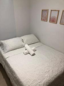 a bed with two white pillows on top of it at Comfortable 2 bedroom apartment with pool in Miramar in Barranquilla +47 photos
