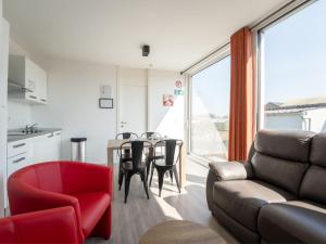 ein Wohnzimmer mit einer Couch und einem Tisch mit Stühlen in der Unterkunft Holiday Home New Dahlia 1 by Interhome in Bredene