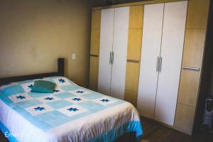 a bedroom with a bed and white cabinets at Casa do Pico in Santo Antônio do Pinhal