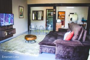 a living room with a brown couch and a coffee table at Casa do Pico in Santo Antônio do Pinhal