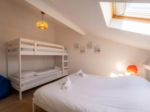 ein Schlafzimmer mit einem Etagenbett und einem weißen Bett in der Unterkunft Holiday Home Melrose by Interhome in Bredene