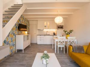 ein Wohnzimmer und eine Küche mit einer Couch und einem Tisch in der Unterkunft Holiday Home Melrose by Interhome in Bredene