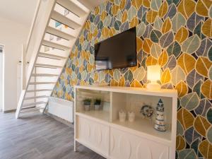 ein Wohnzimmer mit einem Fernseher an der Wand in der Unterkunft Holiday Home Melrose by Interhome in Bredene + 14 Fotos