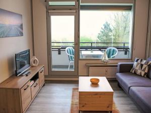 a living room with a couch and a tv at Apartment Ostsee Residenz by Interhome in Damp +21 photos
