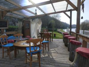 a wooden deck with tables and chairs under a pergola at Chambre d'hôtes dans maison éclusière in Hennebont +7 photos