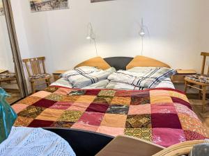 a bed with a colorful quilt on top of it at Holiday Home Hammel by Interhome in Ostseebad Koserow +11 photos