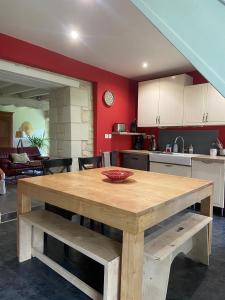 a kitchen with a wooden table in a room at Magnifique Refuge avec piscine et animaux situé au coeur des châteaux de la Loire et des vignobles in Cinais