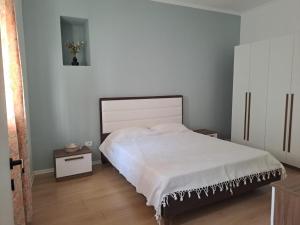 1 dormitorio con 1 cama blanca y armario blanco en Vila Konti 42, en Durrës