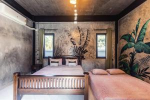Ban Huai YaiにあるNo5 Villa Houseのベッドルーム1室(ベッド2台付)が備わります。壁には壁画が飾られています。 +47枚の写真