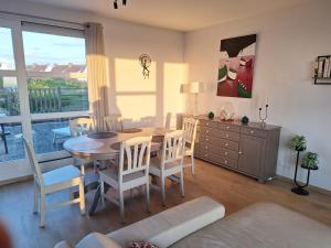 a living room with a table and chairs and a dining room at exceptionnel penthouse vue mer in Wimereux