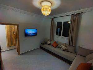 a living room with a couch and a window at Oasis Aglou in Aglou