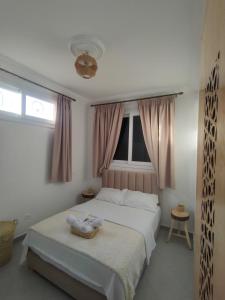 una camera da letto con un grande letto bianco con tende rosa di Oasis Aglou a Aglou Altre 35 foto