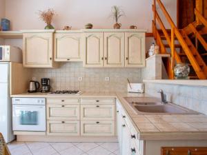 a kitchen with white cabinets and a sink at Holiday Home La Mouette Rieuse by Interhome in La Bernerie-en-Retz