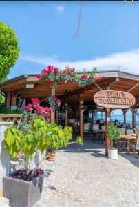 a restaurant with flowers and a sign in front of it at Garden of Eden in Sveti Vlas