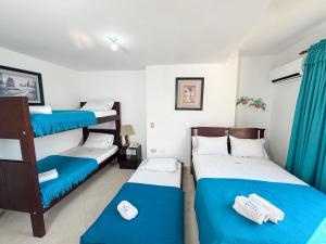a room with two bunk beds and blue curtains at Hotel Puerto Bahia in San Gil +44 photos