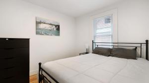 a white bedroom with a bed and a window at Beautiful 4 bedroom home short walk to Niagara Falls in Niagara Falls