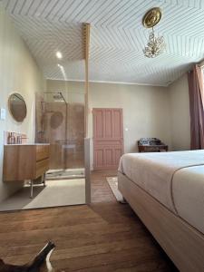a bedroom with a bed and a bathroom with a shower at La Maison Léon in Biscarrosse