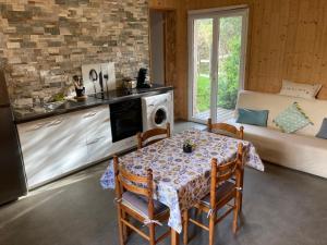 una cucina e una sala da pranzo con un tavolo e un divano di Gîte chez Arthur a Vezzani