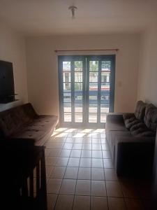 a living room with a couch and a sliding glass door at Pousada Del Mare in Florianópolis