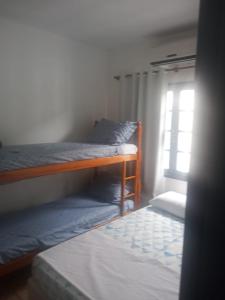 a bedroom with two bunk beds and a window at Pousada Del Mare in Florianópolis