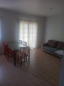 a living room with a table and chairs and a couch at Pousada Del Mare in Florianópolis