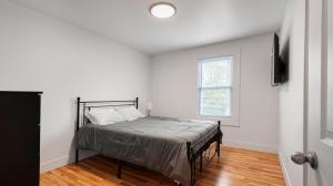 a bedroom with a bed in a white room at Walk to Niagara Falls! Newly Renovated 4 Bedrooms in Niagara Falls