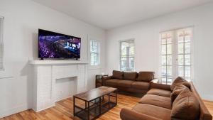 a living room with a couch and a tv on a fireplace at Walk to Niagara Falls! Newly Renovated 4 Bedrooms in Niagara Falls
