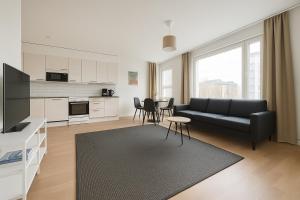 una sala de estar con un sofá y una mesa en Tammer Huoneistot - City Suite 5 - Own Sauna, Air conditioning, Balcony & Best Location, en Tampere