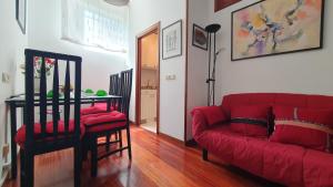 a living room with a red couch and a table at Vivenda Ponte Romana in Padrón