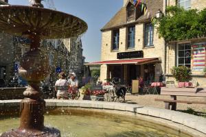 a fountain in the middle of a street with a building at Domaine de La Belle Verte in Le Bô